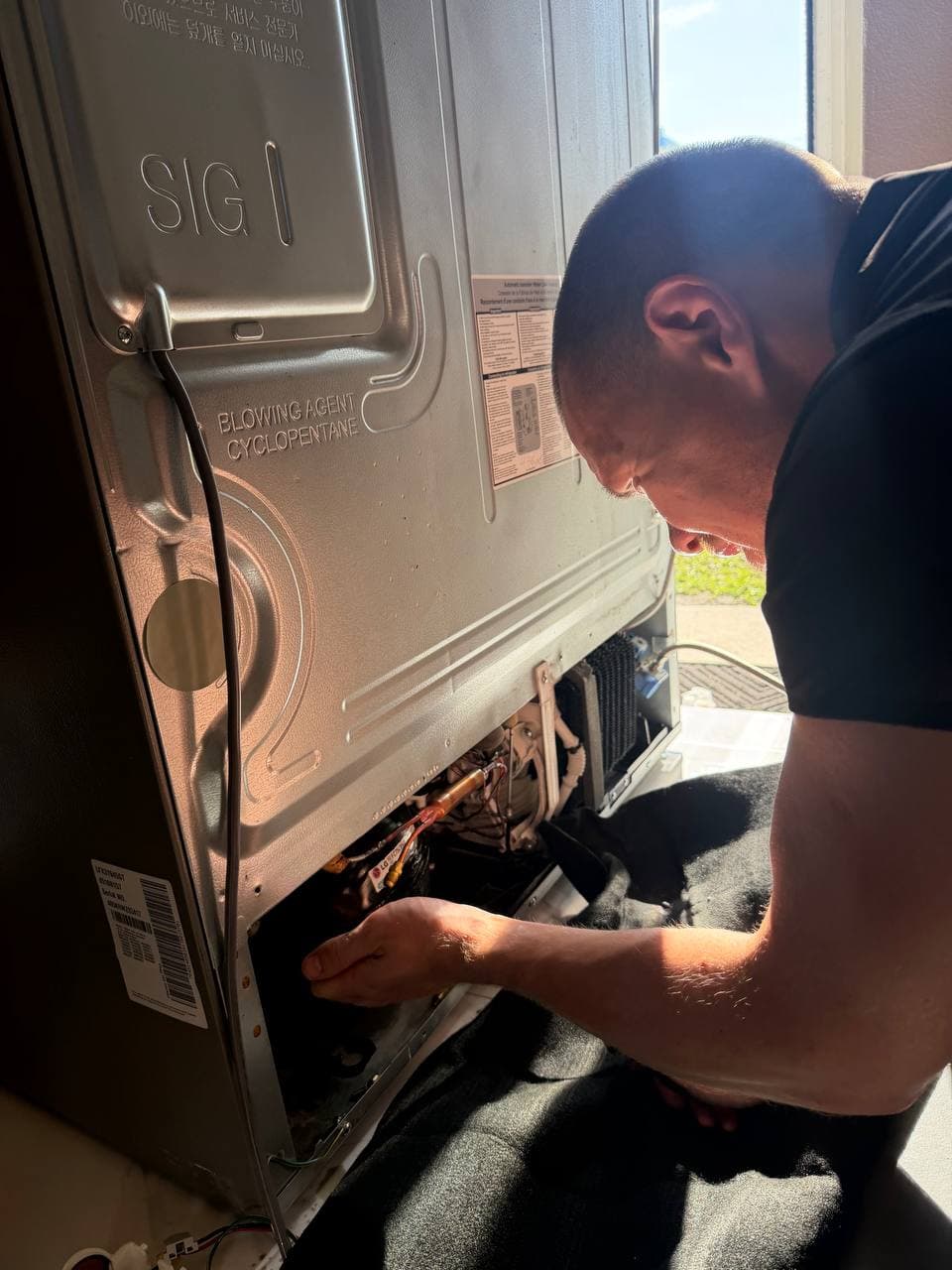 SameDay ApplianceFix technician repairing appliance